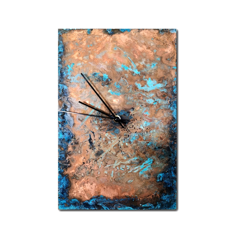 May include: A square copper clock with a blue and brown marbled design. The clock has black hands and a white face.