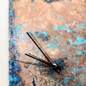 May include: A copper clock face with a blue and brown marbled pattern. The clock has black hands.