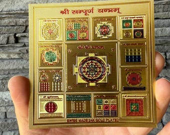Puede incluir: Un cuadrado dorado con intrincados diseños geométricos y texto en idioma extranjero. El cuadrado está dividido en múltiples secciones, cada una con patrones y símbolos únicos. El texto "SWISS MADE 24K GOLD PLATED" es visible en la parte inferior.