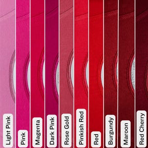 May include: A color palette of nine different shades of pink and red t-shirts. The colors range from light pink to deep red cherry, with labels identifying each shade. The t-shirts have a crew neck design.