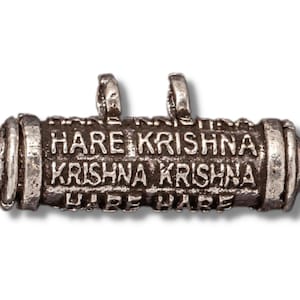 Pode incluir: Encanto de prata em forma de rolo enrolado com as palavras "Hare Krishna Krishna Krishna Hare" gravadas nele.