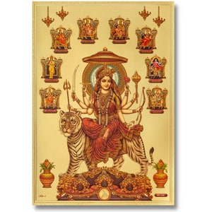 May include: A gold-toned print depicting a multi-armed deity riding a tiger, dressed in red and gold. The central image is surrounded by smaller depictions of other deities. The artwork is framed with a gold border and decorative elements.