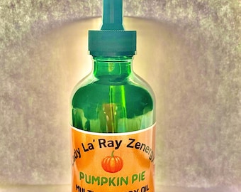 May include: A green glass bottle with a dropper top and a label that reads "Lady La' Ray Zenergy Pumpkin Pie Multi-Use Body Oil For Hair, Skin, and Nails with Pumpkin Seed, Apple Seed, and Essential Oils".