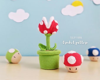 May include: Crocheted plush toy of a Piranha Plant from the Super Mario Bros. video game series. The plant is red with white spots and is in a green pot. There are also three crocheted mushroom toys, one red with white spots, one green with white spots, and one blue.
