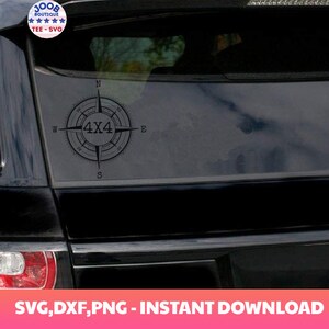 May include: A black car with a compass sticker on the back window. The compass has a 4x4 design in the center.
