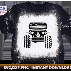 May include: Black and white silhouette of a Jeep with an American flag on the bonnet and a peace sign on the grille. The image is on a black t-shirt with a white splatter effect.