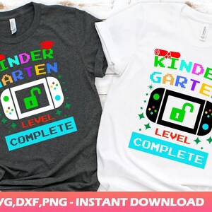 May include: Two t-shirts featuring a video game design that reads "Kindergarten Level Complete". The shirts are in different colours, one is dark grey and the other is white.