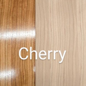 May include: Close-up of two wood samples, one finished and one unfinished. The finished sample is a rich cherry color, while the unfinished sample is a light, natural wood color. The text "Cherry" is visible in the image. The text "Example ONLY" and "All wood is raw/unfinished" is also visible. The text "Finished" and "Unfinished" is visible below the wood samples.