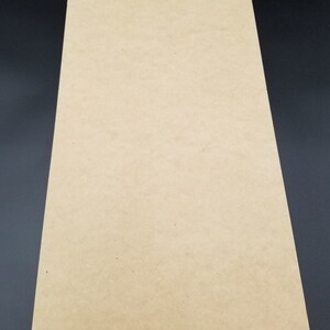 Puede incluir: Una hoja de papel kraft liso de color marr&oacute;n claro.