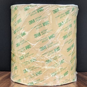May include: A roll of brown 3M 467MP 200MP Adhesive tape wrapped in clear plastic. The tape is labelled with the text "3M 467MP 200MP Adhesive".