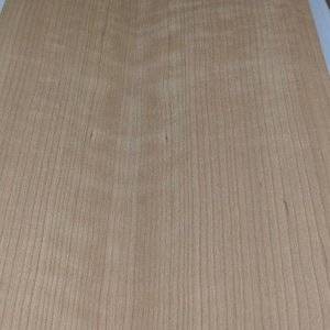 May include: A sheet of light brown wood veneer with a wood grain pattern.