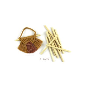 May include: A small macrame wall hanging with a brown and orange color scheme and fringe. The hanging is 3 inches wide and comes with 12 wooden dowels.