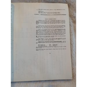 Pu&ograve; includere: Un documento stampato con testo su carta bianca. Il documento &egrave; aperto, rivelando diversi paragrafi di testo in nero. La carta &egrave; rilegata con un dorso blu. Il documento sembra essere un rapporto o una lettera.