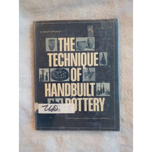 May include: A black book with the title "The Technique of Handbuilt Pottery" by Mollie  Enterline. The book cover features a variety of handbuilt pottery pieces in black and white.
