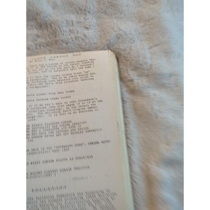 Pu&ograve; includere: Primo piano di un libro vintage con testo manoscritto su carta invecchiata. Le pagine sono bianco sporco e il testo &egrave; in inchiostro nero. L'angolo del libro &egrave; visibile su uno sfondo morbido e strutturato.