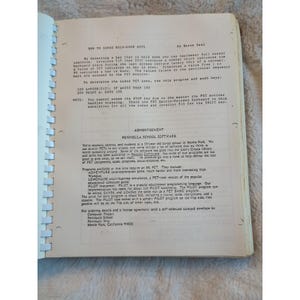 Pu&ograve; includere: Libro aperto con testo manoscritto e stampato sulla programmazione informatica. Il testo include istruzioni su come utilizzare un computer PET e una pubblicit&agrave; per Peninsula School Software.