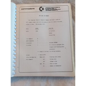 Pu&ograve; includere: Pagina di quaderno aperta con testo e diagrammi sulla memoria utente PET. Il logo Commodore &egrave; in alto a sinistra. Il testo include parole chiave BASIC, variabili e informazioni sugli array. Pagina da un manuale di computer vintage.