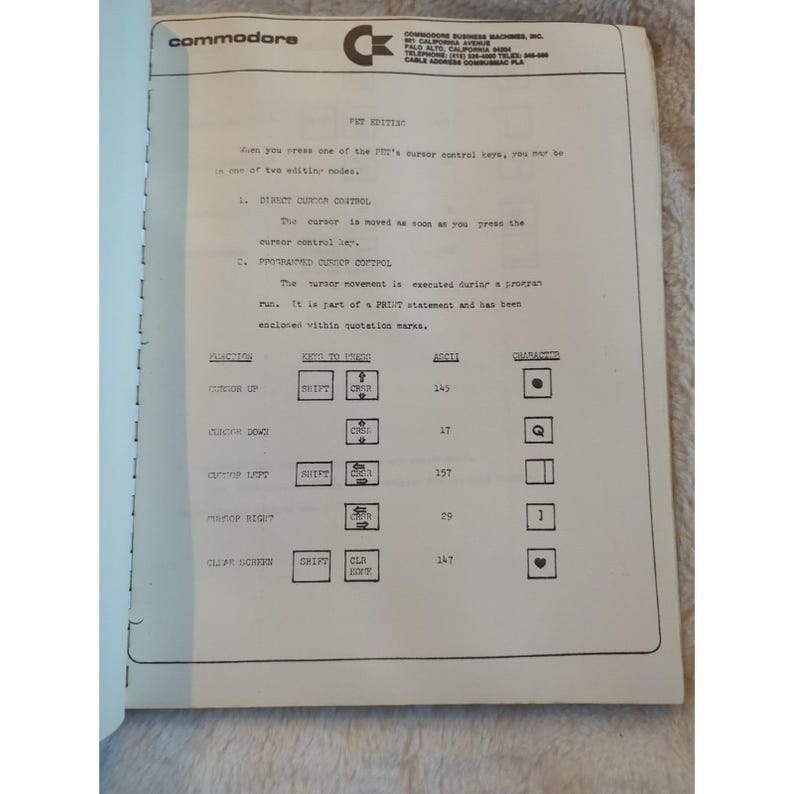 Pu&ograve; includere: Una pagina di un manuale vintage di Commodore PET Edition. Il testo e i diagrammi spiegano le funzioni di controllo del cursore. Il logo Commodore &egrave; in alto, insieme all'indirizzo dell'azienda. La carta ha un aspetto ingiallito e invecchiato.