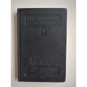 May include: A vintage black book with the title "INTERNATIONAL LIBRARY" embossed on the cover. The book also features the text "INTERNATIONAL TEXTBOOK COMPANY SCRANTON, PA." and an emblem.