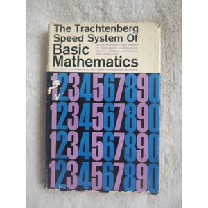 Puede incluir: Un libro antiguo titulado "The Trachtenberg Speed System Of Basic Mathematics". La portada presenta números grandes y coloridos en azul y morado. El libro promete un método revolucionario para las matemáticas rápidas.