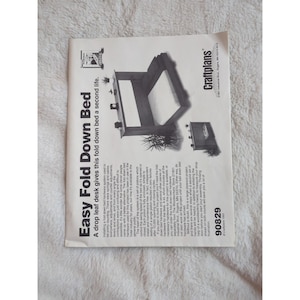 Op de afbeelding: Een bedrukte pagina met de titel "Easy Fold Down Bed" en een illustratie van een bedframe. De tekst beschrijft een drop-leaf bureau hardware systeem voor een opklapbed, met details over installatie en componenten.