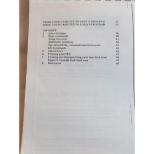 Pu&ograve; includere: Una pagina di un manuale con i titoli "UTILIZZO DEL TUO CASSETTE PER SALVARE UN PROGRAMMA" e "UTILIZZO DEL TUO CASSETTE PER CARICARE UN PROGRAMMA". L'appendice elenca i messaggi di errore e i comandi di base.