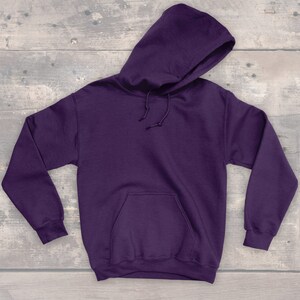Puede incluir: Una sudadera con capucha de color morado con un bolsillo canguro en la parte delantera.