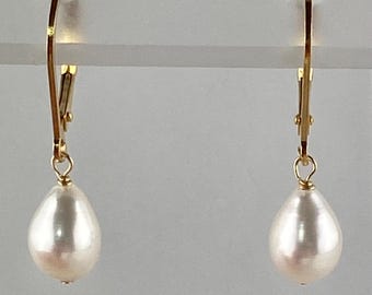 May include: A pair of gold dangle earrings with white pearl drops.