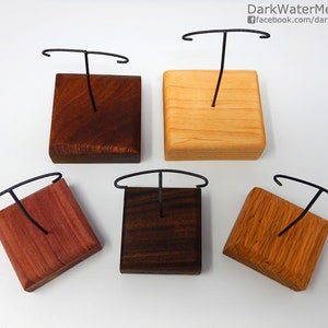 May include: Five wooden display stands with a black wire stand for displaying items. The stands are made of different types of wood, including cherry, walnut, maple, and oak.