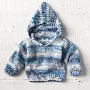 One of a kind; hand knit baby hoodie in size 12 - 18 months. Gorgeous soft yarn in stripes and waves of blue and cream.