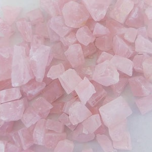 May include: A large pile of pink rose quartz crystals. The crystals are various shapes and sizes.