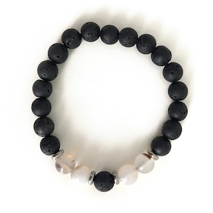 May include: A black lava rock beaded bracelet with white agate beads and silver metal accents.
