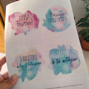 Puede incluir: Cuatro etiquetas de estilo acuarela con mensajes motivacionales en italiano. Las etiquetas est&aacute;n impresas en papel blanco. Los mensajes son: "Pensa Positivo!" (&iexcl;Piensa positivo!), "Messaggi Motivazionali" (Mensajes motivacionales), "Il Barattolo della Motivazione" (El tarro de la motivaci&oacute;n), y "Trova la tua Motivazione" (Encuentra tu motivaci&oacute;n).