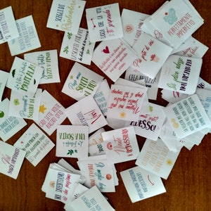 May include: A collection of small, colorful cards with inspirational quotes and phrases written in Italian. The cards are printed on white paper and have a variety of fonts and designs.