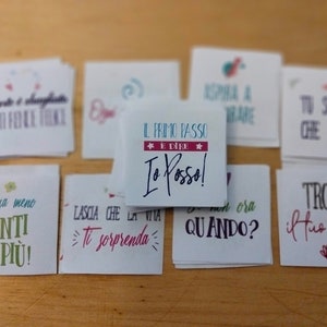 May include: A set of small white cards with inspirational quotes in Italian. The cards feature colorful illustrations and handwritten text. Some of the quotes include "Il primo passo e dire Io posso!" and "Penja meno Senti di piu!"