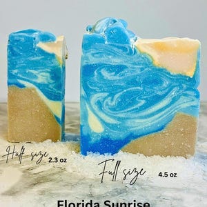Puede incluir: Dos barras de jab&oacute;n Florida Sunrise, una de tama&ntilde;o medio y otra de tama&ntilde;o completo, con un dise&ntilde;o de playa. El jab&oacute;n presenta colores azul, blanco y beige, que se asemejan a las olas del oc&eacute;ano y la arena. La barra completa pesa 128 gramos, y la media pesa 65 gramos.