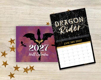 May include: A 2027 wall calendar featuring a purple cover with a black dragon silhouette and the text 2027 Wall Calendar. The open page displays the title Dragon Rider in gold lettering above a January 2027 grid on a black background.