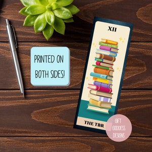 May include: A bookmark with a stack of colorful books, a yellow background, and the text "THE TBR" and "XII". The bookmark also has a pink circle with the text "GIFT GODDESS DESIGNS".
