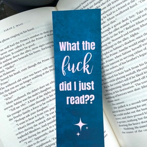 Puede incluir: Un marcap&aacute;ginas azul con un dise&ntilde;o de estrella rosa y el texto "What the fuck did I just read?" en letras rosas.