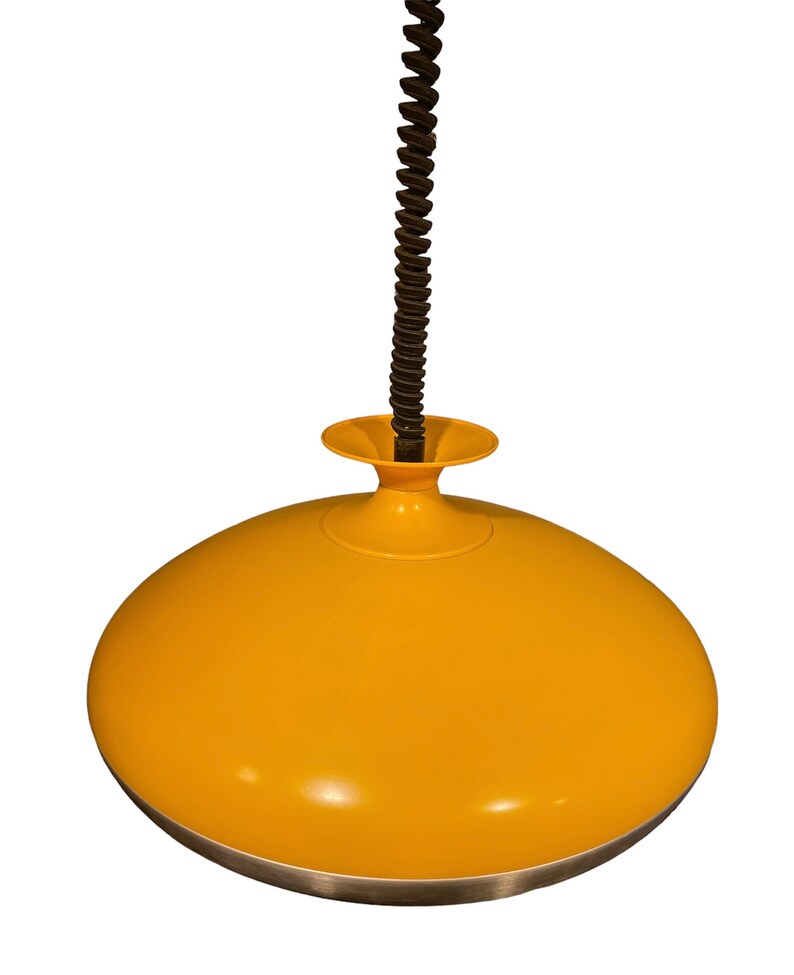 May include: A yellow pendant light with a black cord and a silver trim. The light is shaped like a dome.