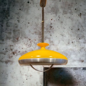 May include: A yellow and silver ceiling light fixture with a saucer-shaped shade.