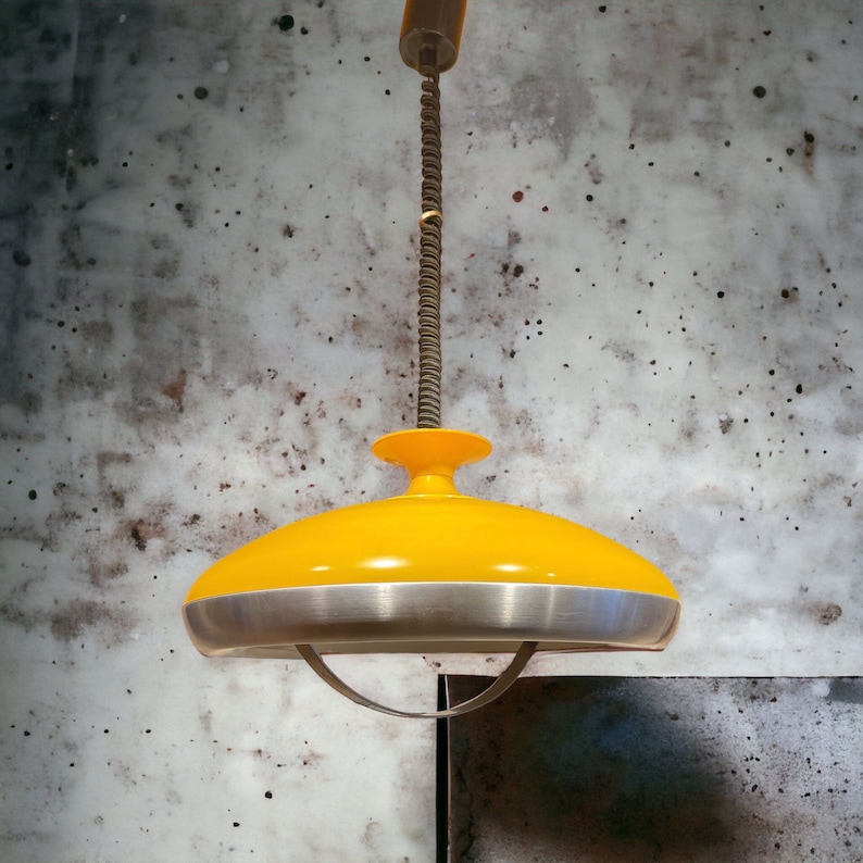 May include: A yellow and silver ceiling light fixture with a saucer-shaped shade.