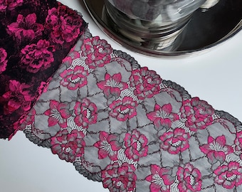 Könnte beinhalten: Schwarze und rosafarbene florale Spitzenborte mit einem zarten Muster. Die Spitze ist weich und dehnbar, wodurch sie perfekt ist, um jedem Projekt einen Hauch von Eleganz zu verleihen.
