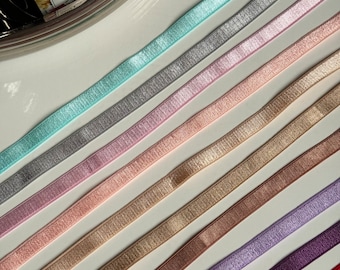 Può includere: Assortimento di 10 nastri elastici di diversi colori con un leggero luccichio. I colori sono turchese, argento, rosa, pesca, beige, oro, marrone, lavanda, viola e rosso.