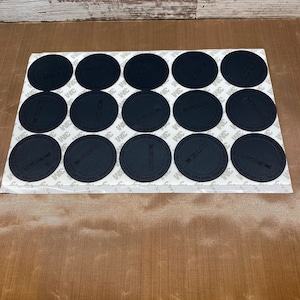 May include: A sheet of 15 black round stickers with the text "3M" and "Hand wash only" printed on them.