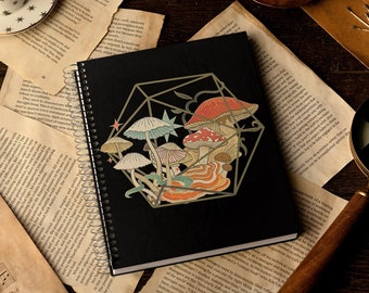 May include: A black spiral notebook with a geometric design featuring colorful mushrooms. The notebook has a gold-colored geometric design with a star and a vine.