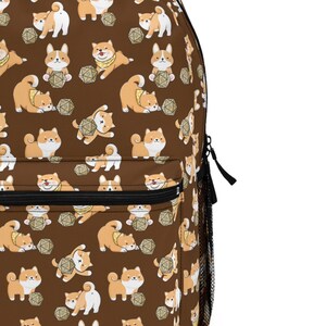 May include: Brown backpack with a repeating pattern of Shiba Inu dogs playing with a 20-sided die.