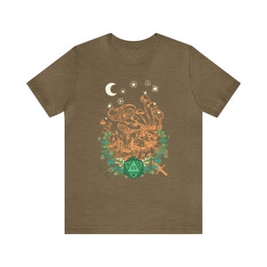 May include: A brown t-shirt with a green 20-sided die, orange mushrooms, and a crescent moon with stars in the background.