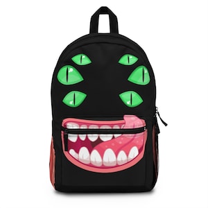 May include: Black backpack featuring a cartoon monster face. The monster has a wide open mouth with teeth and a pink tongue sticking out. It has five green eyes.