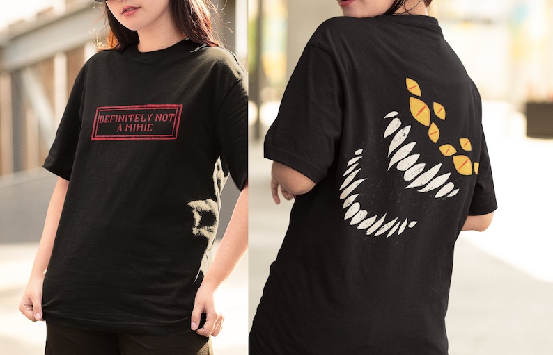 May include: Black t-shirt with a red box on the front that says "DEFINITELY NOT A MIMIC". The back of the shirt has a white graphic of a large mouth with yellow eyes.